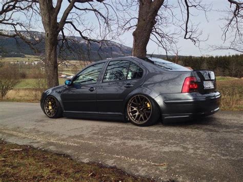 the car is parked on the side of the road next to some trees and grass