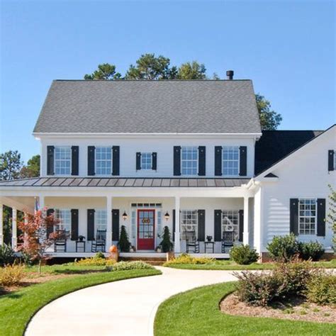 a large white house with black shutters on the front