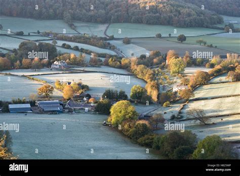 House and farmland in the valley of Downham Hill from Uley Bury on a cold frosty autumn morning ...