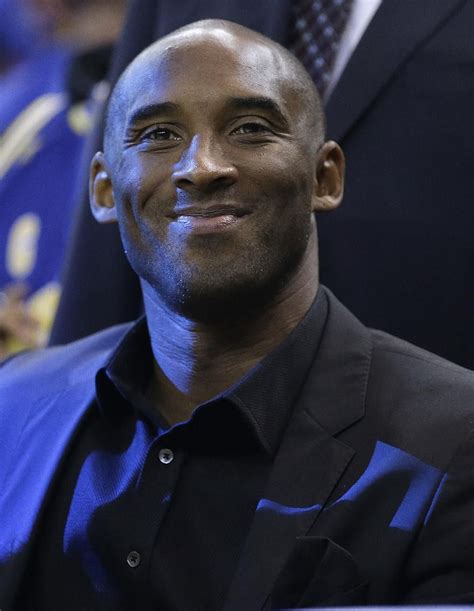 Los Angeles Lakers' Kobe Bryant smiles at a fan from the sideline ...