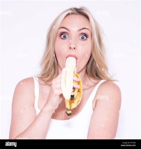 Pretty blonde woman eating a banana Stock Photo - Alamy