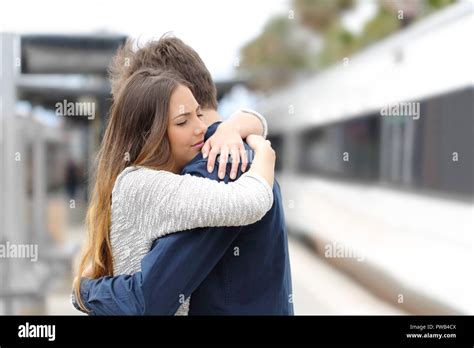 Sad couple hugging saying goodbye before train travel Stock Photo - Alamy