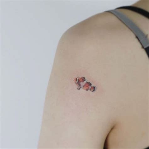 Clown fish by Flower | Foot tattoos, Small fish tattoos, Tiny tattoos