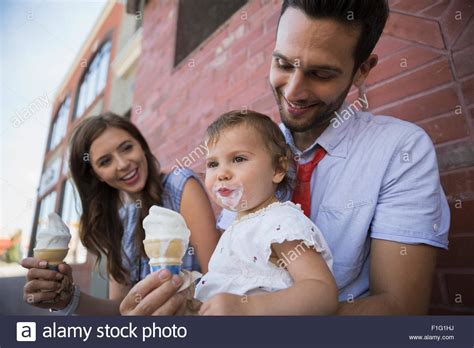 Father holding daughter with messy ice cream face Stock Photo - Alamy