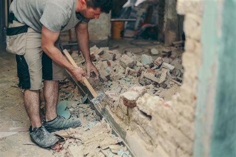 Premium Photo | A young man breaks a brick wall with a sledgehammer