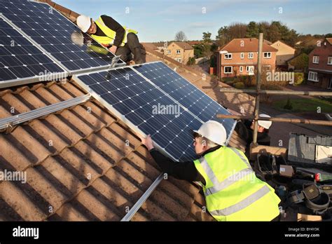 Installing photo voltaic solar panels onto the roof of a domestic house within Washington, North ...