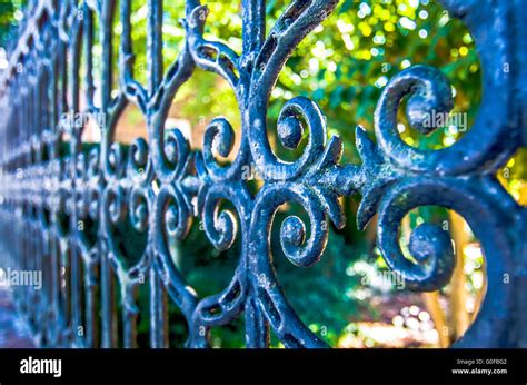 Classical design black wrought iron gate in a beautiful green garden Stock Photo - Alamy