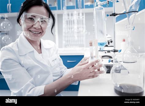 Joyful female scientist smiling while holding test tubes Stock Photo - Alamy