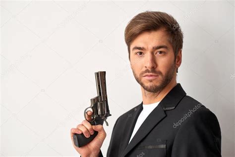 Handsome man holding a gun — Stock Photo © yacobchuk1 #102474444