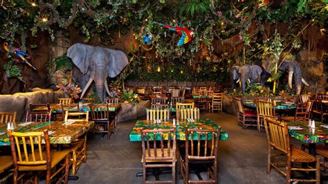 Tables surrounded by foliage and statues of elephants and parrots