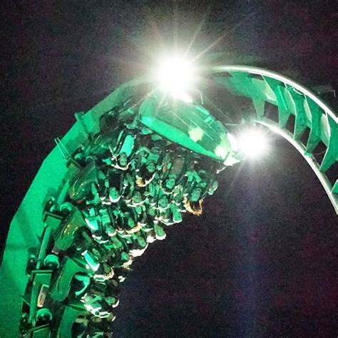 Riders spin around as they are shot out of the launch tunnel at night ...