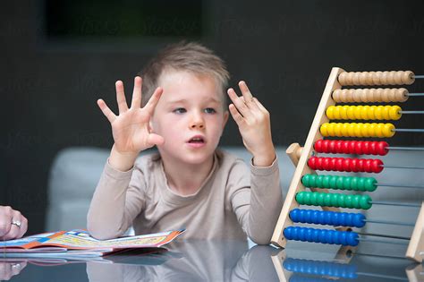 "Young Boy Counting On Fingers" by Stocksy Contributor "Lee Avison" - Stocksy