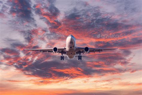 Landing passenger airplane at colorful sunset Stock Photo by den-belitsky