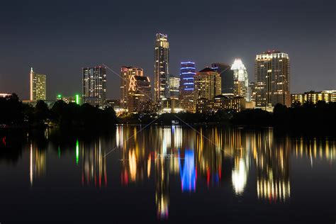 Beautiful Sunset falls on the Austin Skyline as water enthusiast kayak and canoe on Lake Austin ...