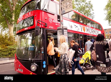 People in a queue to get on a london bus, passengers boarding bus Islington London England UK ...