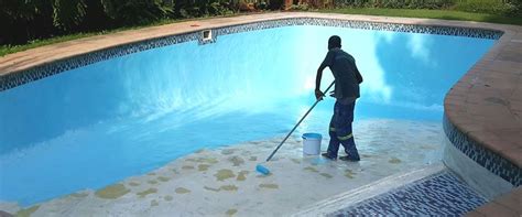 a man with a mop is cleaning the pool