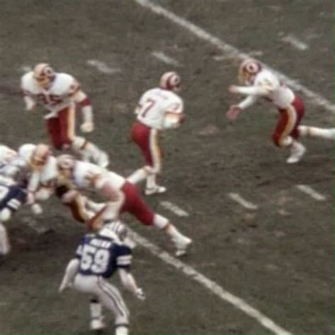 a group of football players are playing on the field with their hands in each other's pockets