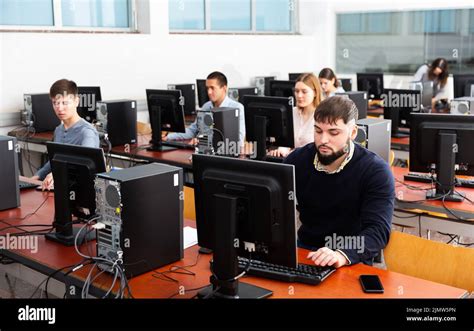 Group of people learning to use computers in classroom Stock Photo - Alamy