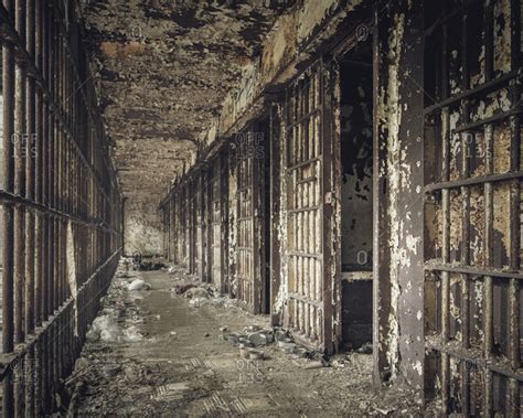 Hall of jail cells in an abandoned prison stock photo - OFFSET