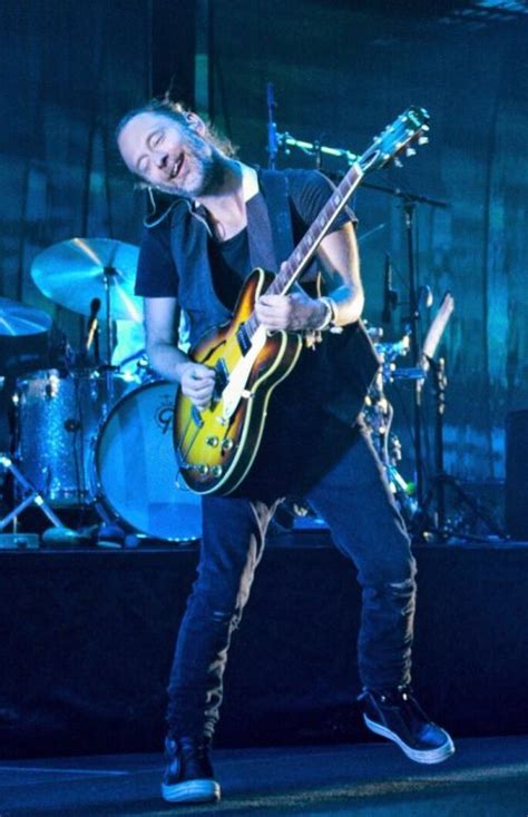 a man playing guitar on stage at a concert