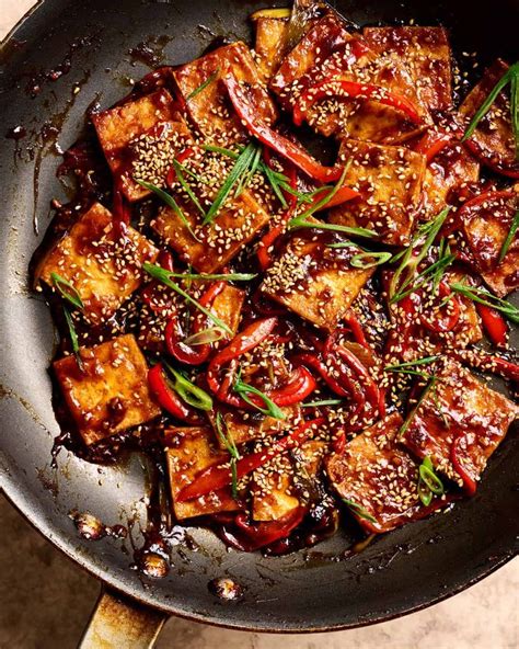 tofu with red peppers and sesame seeds in a skillet