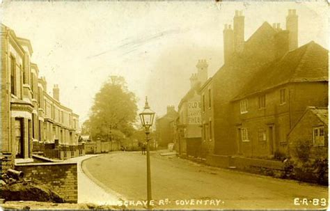 an old photo of a street with buildings and a lamp post in the foreground