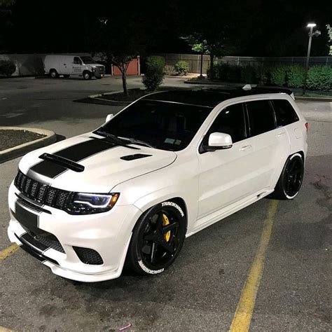 a white jeep parked in a parking lot at night