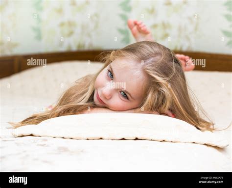 Little girl lying on the bed Stock Photo - Alamy