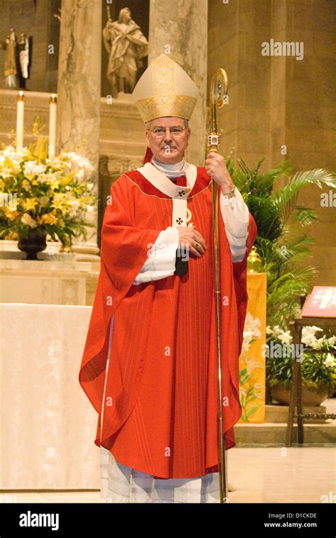 Catholic Priest wearing red vestments presiding over confirmation Mass. Basilica of "St Mary ...