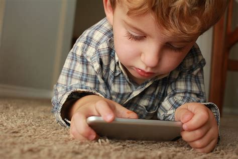 boy, holding, smartphone, lying, rug, brown, carpet, looking, CC0, public domain, royalty free ...