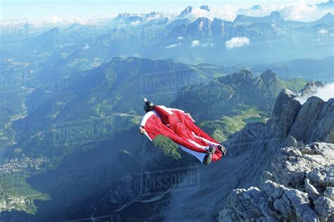 Male wingsuit BASE jumper taking off from cliff edge - Stock Photo ...