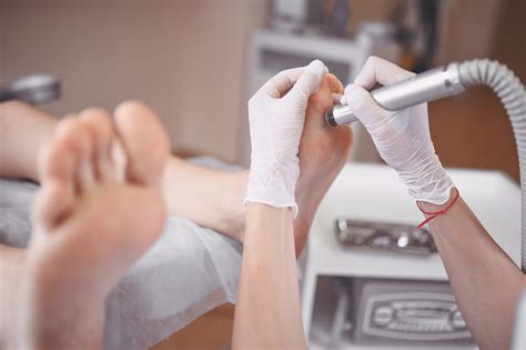 Podiatrist using grinding equipment and making procedure polish for feet pedicure. Podology ...