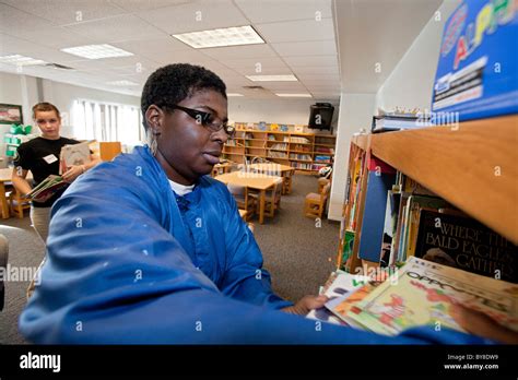 Volunteers Organize Books in School Library Stock Photo - Alamy