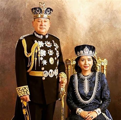 a man and woman dressed in costumes posing for a photo with a gold crown on their head