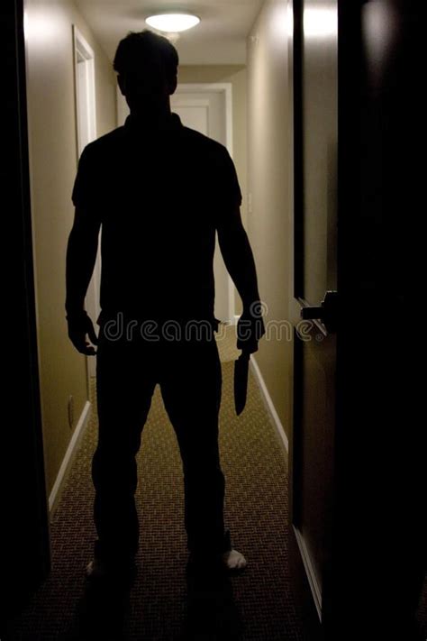 Man With Knife. A mans silhouette is shown coming into a dark room ...