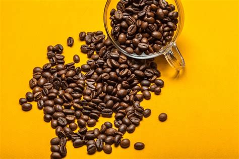 Premium Photo | Spilled coffee beans on a bright yellow