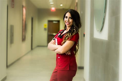 a woman in red scrubs is posing for the camera with her arms crossed ...