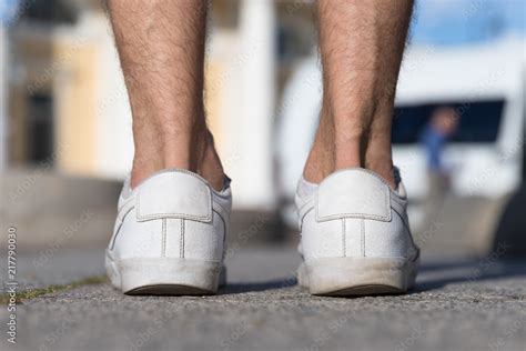 Flat foot, sole, posture concept. Irregular wear heel male shoes, closeup back view outdoors ...