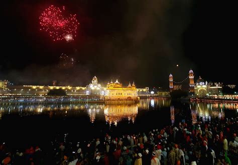 Devotees watch fireworks explode over the illuminated Golden Temple.