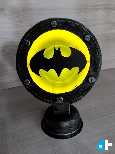 a black and yellow light with a batman symbol on it's face is sitting ...