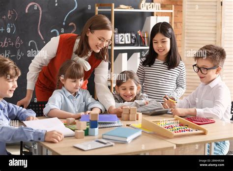 Children with math teacher during lesson in classroom Stock Photo - Alamy