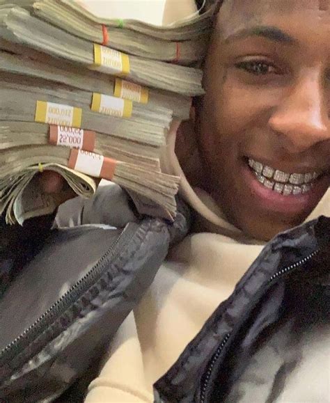 a man is holding stacks of money in his hands and smiling at the camera ...