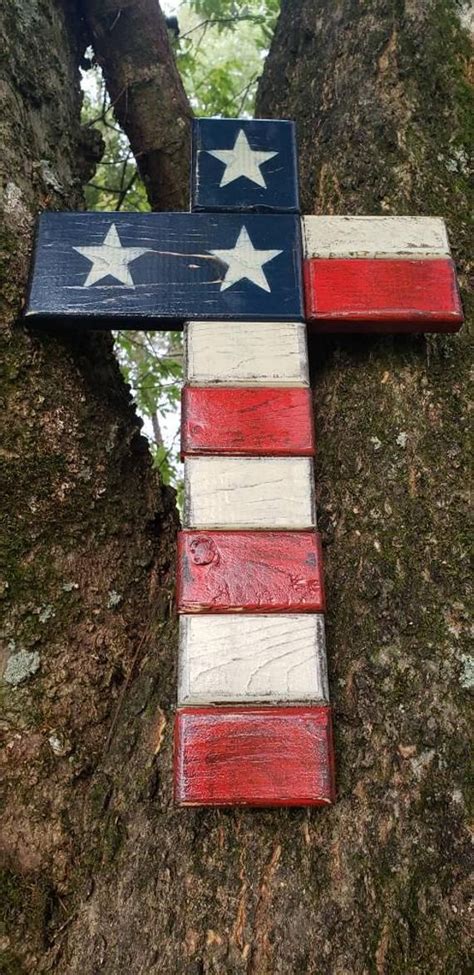 a cross made out of wooden planks in the shape of an american flag on a tree