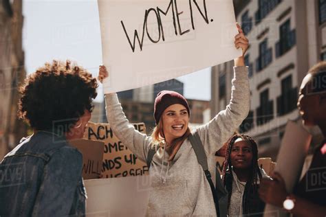 Group of females activist protesting on road for women empowerment. Smiling young woman holding ...