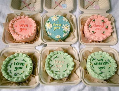 six decorated cupcakes in small trays with writing on the top and bottom