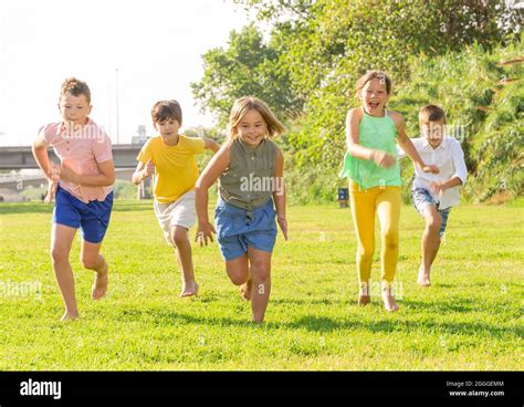 Barefoot kids running on green grass Stock Photo - Alamy