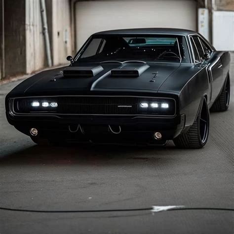 a black muscle car is parked in front of a garage with its hood up and ...