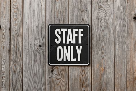 Black and white square STAFF ONLY sign attached to a wooden wall. Stock ...