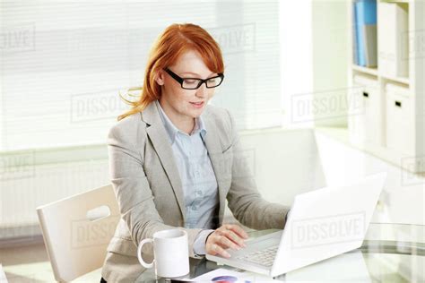 Young female manager working in office - Stock Photo - Dissolve