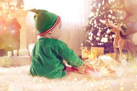 Premium Photo | Baby in cute elf costume near christmas gift on floor ...